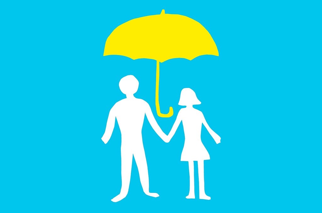 Rodzic z dzieckiem pod parasolem